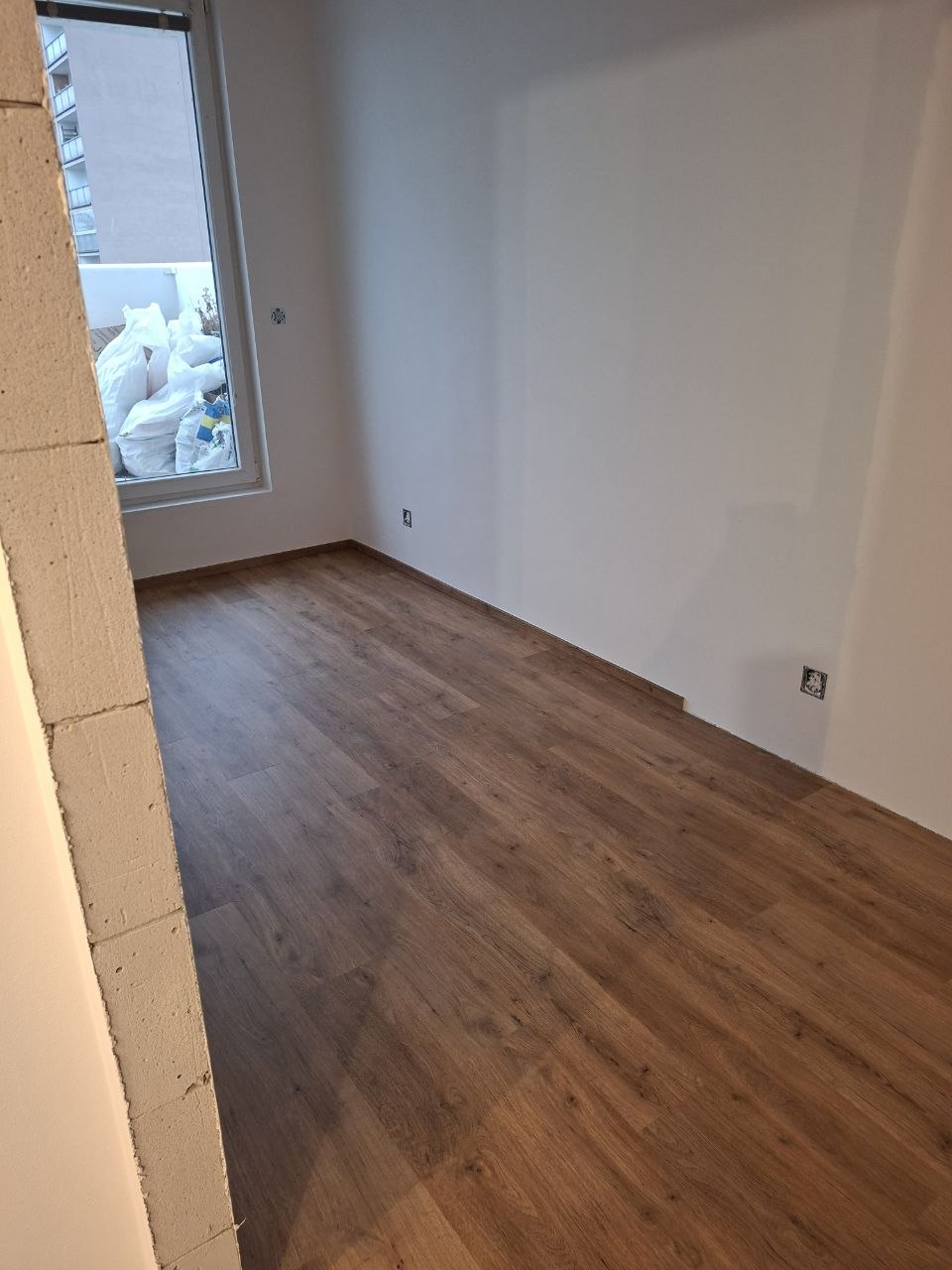 Položená nová dřevěná podlaha v místnosti připravené na malování